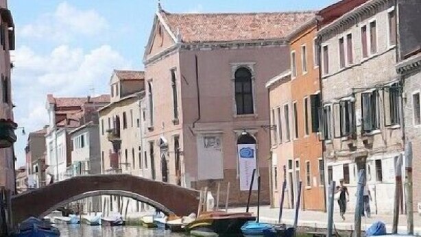 A canal with boats, a bridge, and buildings with traditional architecture. - Romantic Attic with Superb View of Madonna del Orto Gothic Church (Venezia)