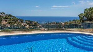 A clear blue pool with a view of the sea and a hillside. - Wonderful private villa for 10 people with private pool, WIFI, TV and pets allowed (Lloret De Mar)