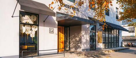A modern hotel with a minimalist facade, large windows, and a visible entrance.