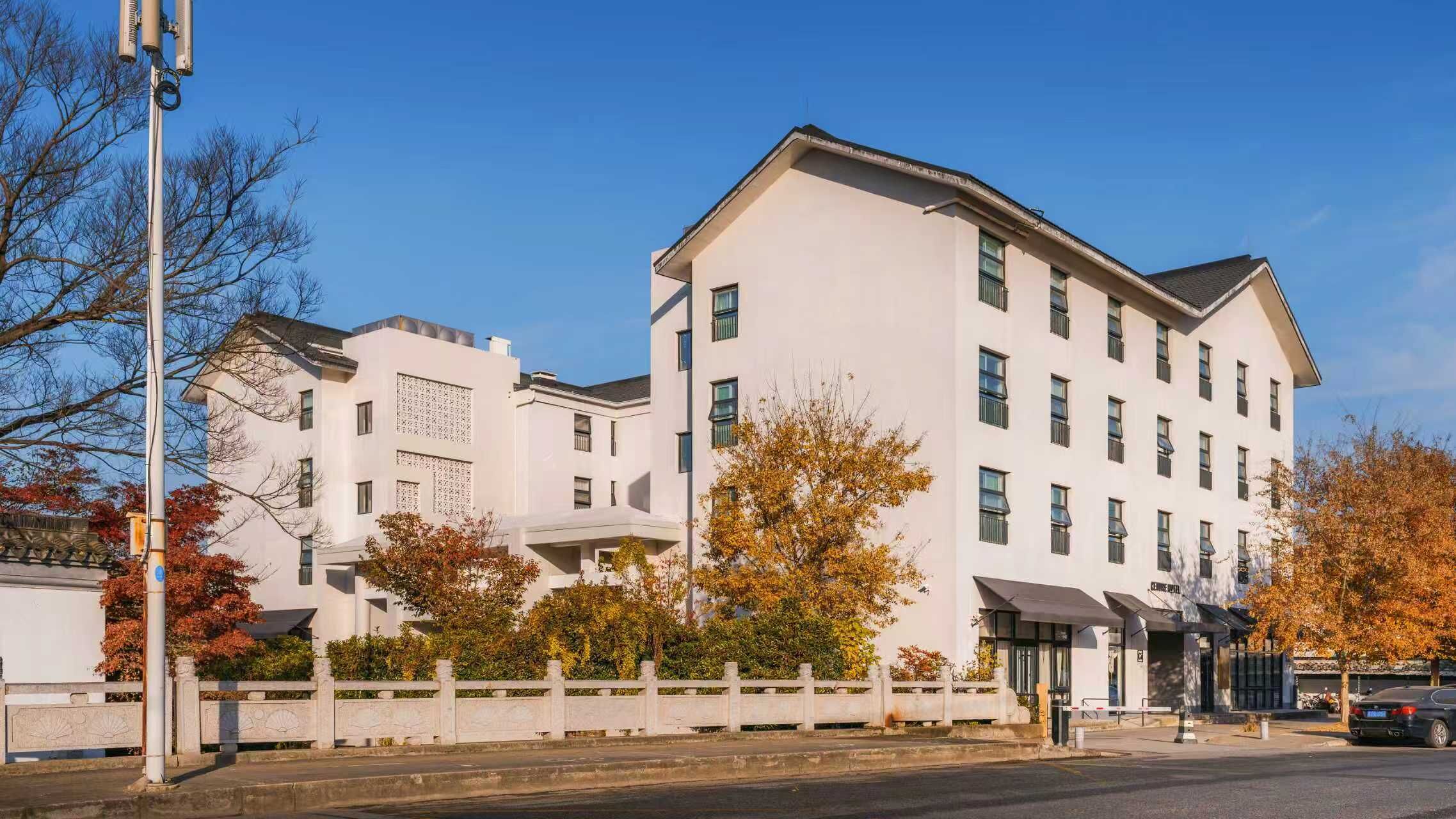 A multi-story building with a flat roof, large windows, and a white facade.