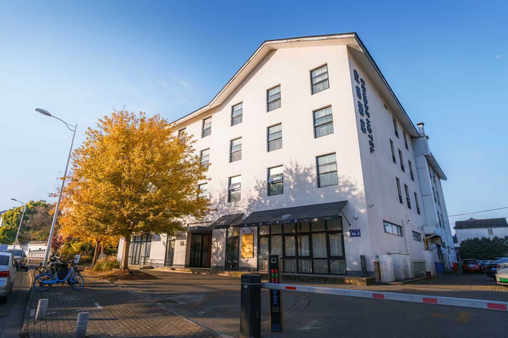 A multi-story building with a white facade and multiple windows.