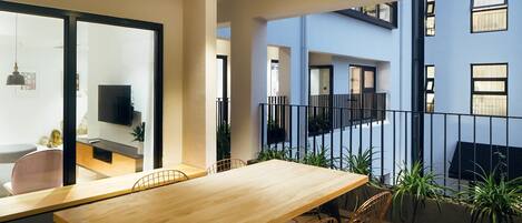 Un apartamento moderno con una mesa de comedor de madera, sillas y un televisor en la sala de estar.
