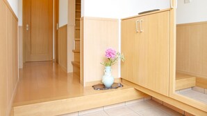 A hallway with wooden cabinets, a tiled floor, and a vase with flowers. - 4-bedrooms 2-toilet 2-bathroom near FushimiInari with free parking (Kyoto)