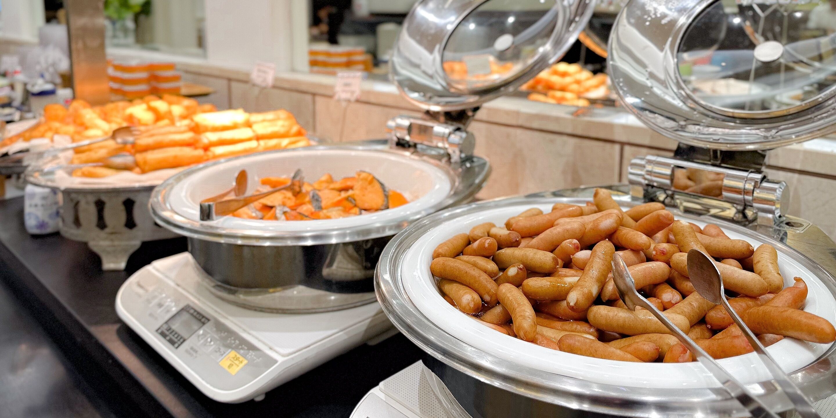 A buffet with various food items including sausages and other dishes.