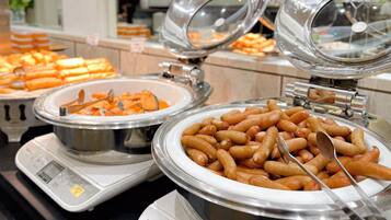 A buffet with various food items including sausages and other dishes.