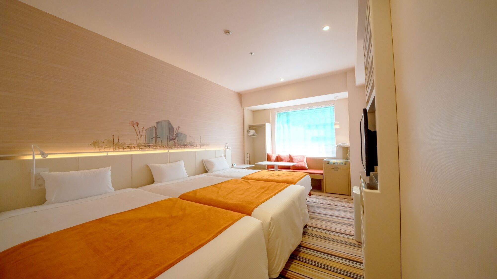 A hotel room with two beds, a TV, a desk, and a window with curtains.