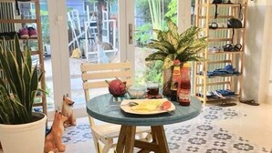 A cozy indoor seating area with a round table, chairs, and a potted plant. - Quy Nhon Homestay BnB (Quy Nhon Nam)