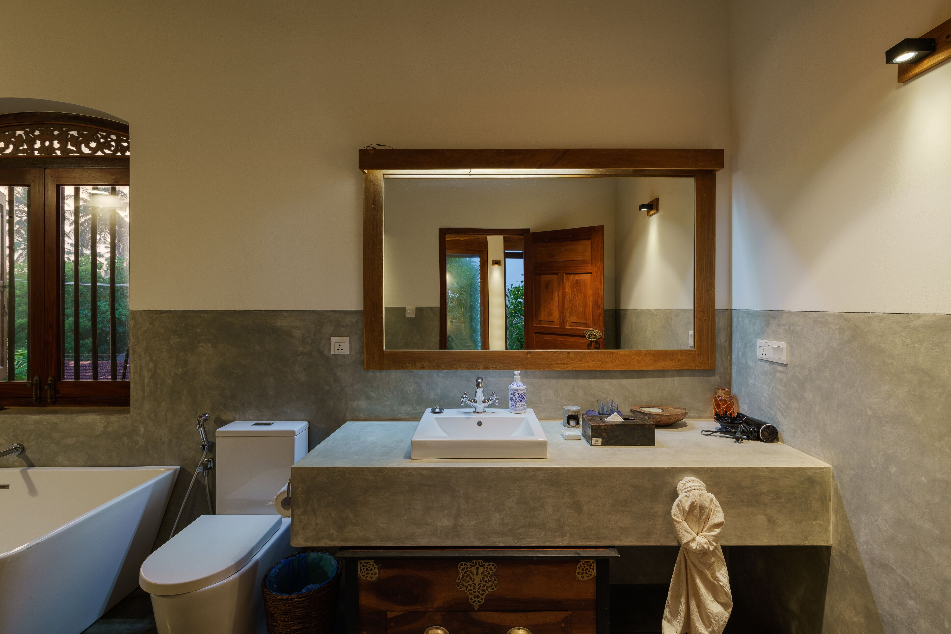 A bathroom with a bathtub, toilet, sink, and a mirror above the sink.