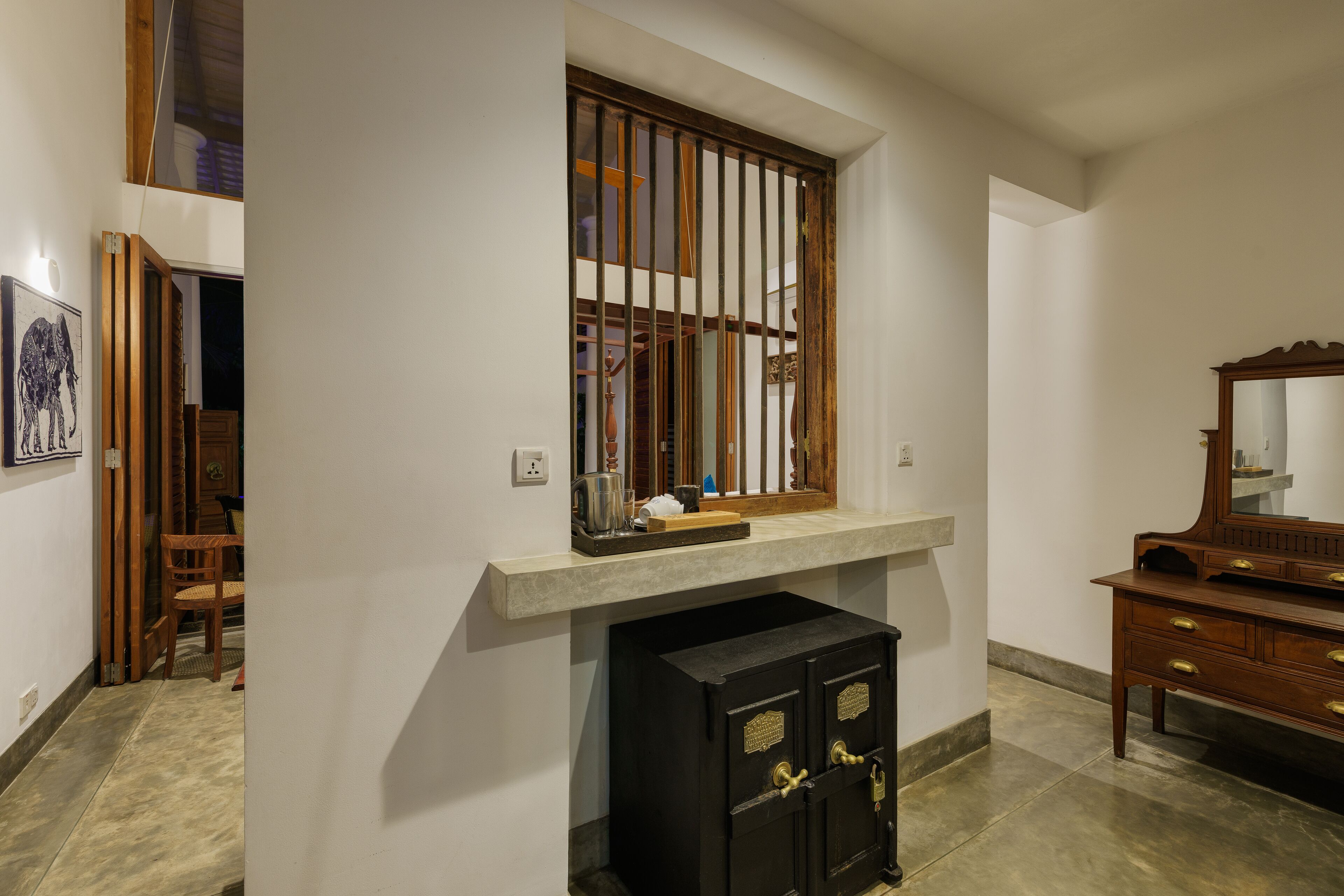 A room with a window, a wooden cabinet, and a dresser.