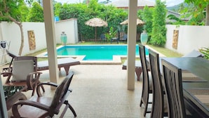 A covered outdoor area with a pool, lounge chairs, and a table. - Wirason 2-Bedroom Pool Villa (Koh Samui)