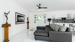 A modern living room with a sectional sofa, a coffee table, and a TV. - Wirason Villa 4 Bedrooms (Koh Samui)