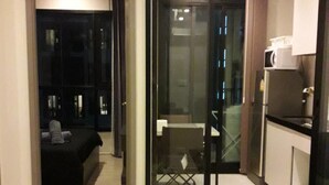 A modern hotel room with a glass partition separating the living area from the bedroom. - The Base Central Pattaya by Arawat (Pattaya)
