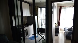 A modern apartment with a kitchen, dining area, and a bedroom. - The Base Central Pattaya by Arawat (Pattaya)