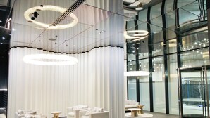 Een moderne lobby met witte banken, ronde tafels en grote ronde kroonluchters.