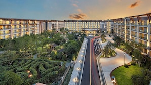 A modern hotel with multiple floors, a central courtyard, and a well-lit entrance. - Shinhwa Jeju Shinhwa World Hotel & Resorts (Seogwipo)