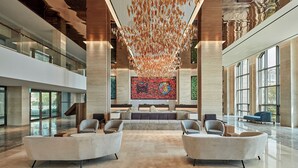 A spacious lobby with a central seating area, large windows, and a modern ceiling design. - Shinhwa Jeju Shinhwa World Hotel & Resorts (Seogwipo)
