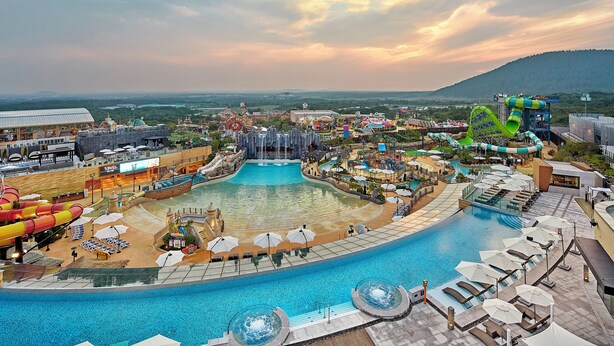 A water park with a large pool, slides, and a waterfall attraction. - Shinhwa Jeju Shinhwa World Hotel & Resorts (Seogwipo)