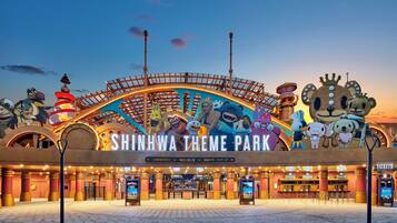 Shinhwa Theme Park entrance with a large sign, ticket booth, and a queue area.