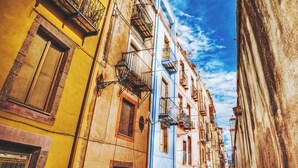A narrow street with multi-story buildings, balconies, and a clear sky. - Apartment in private house with small terrace, panoramic view, external veranda (Magomadas)