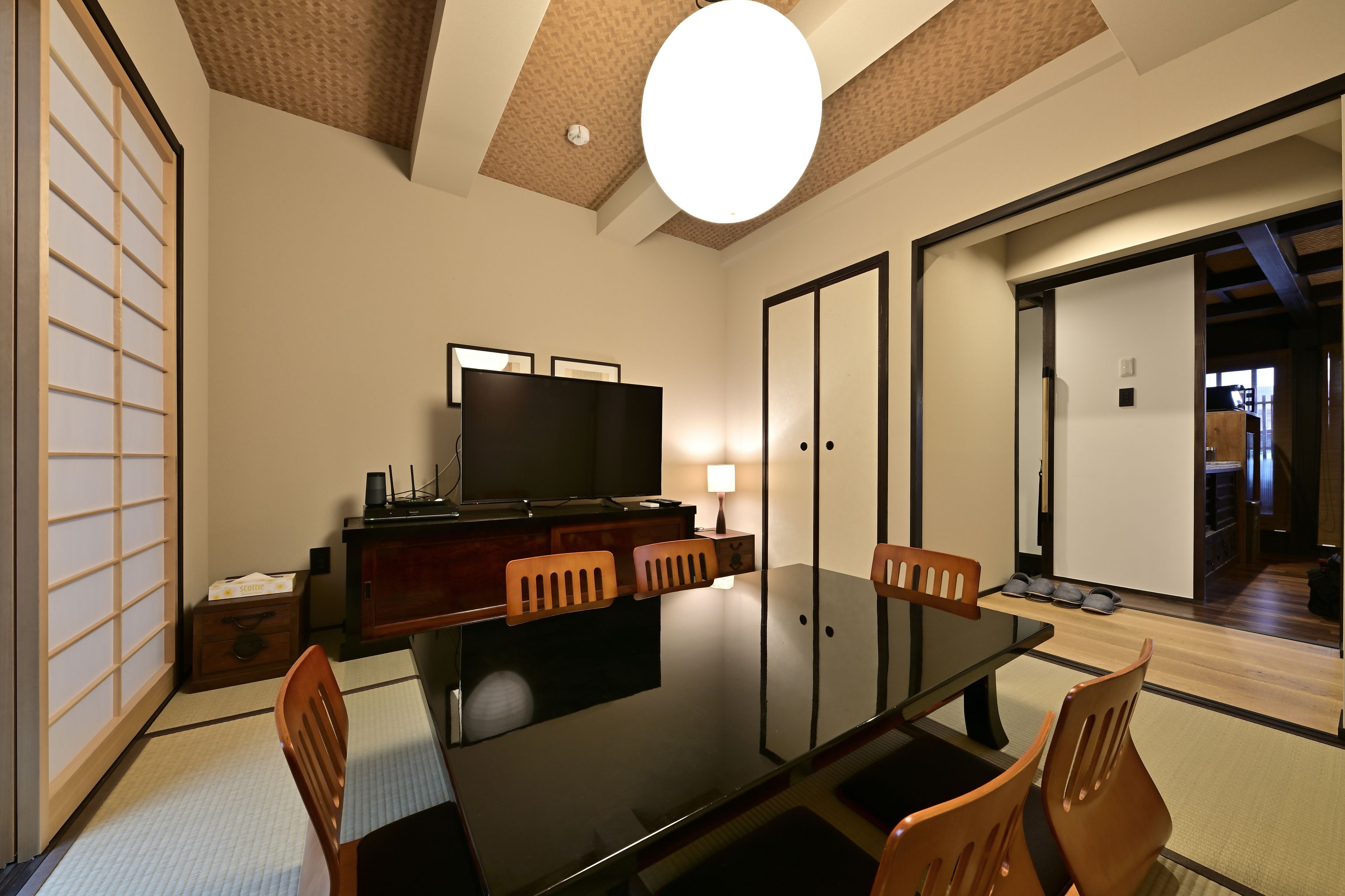 A traditional Japanese-style room with tatami flooring, a low table, and sliding doors.