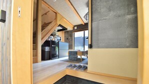 Una cocina compacta con microondas integrado, refrigerador y un pequeño comedor con mesa y sillas.
