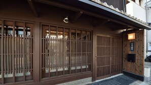 Un edificio japonés tradicional con puertas correderas de madera y un felpudo negro.