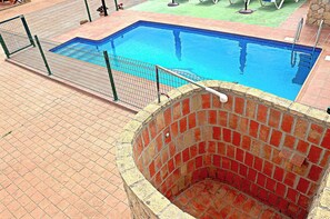 A swimming pool with a brick structure, surrounded by a tiled deck and a metal fence. - Rustic holiday villa for 5 people (CONIL DE LA FRONTERA)