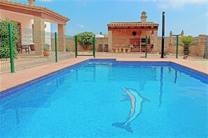 A swimming pool with a tiled edge, surrounded by a brick wall and a fence. - Rustic holiday villa for 5 people (CONIL DE LA FRONTERA)