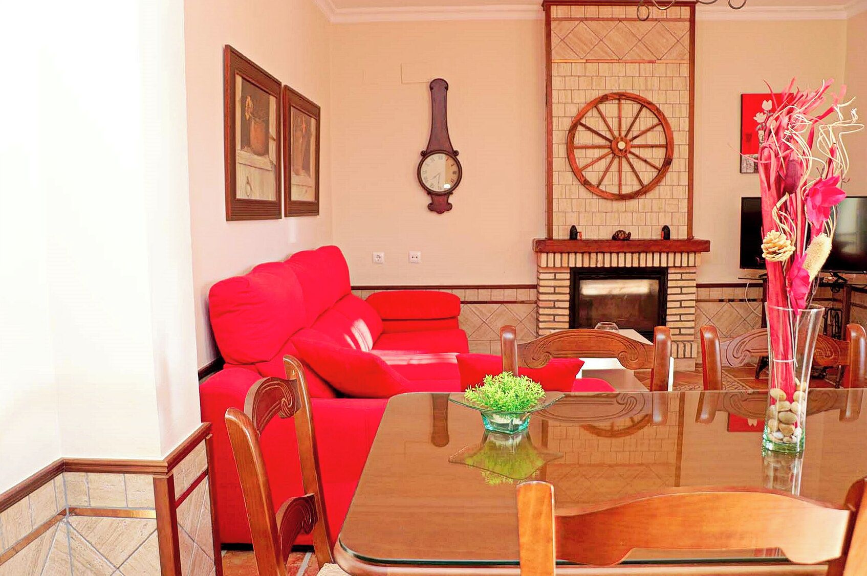 A living room with a red sofa, a wooden coffee table, and a fireplace.