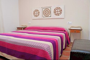 A bedroom with two beds, a nightstand, a dresser, and decorative wall art. - Rustic holiday villa for 5 people (CONIL DE LA FRONTERA)