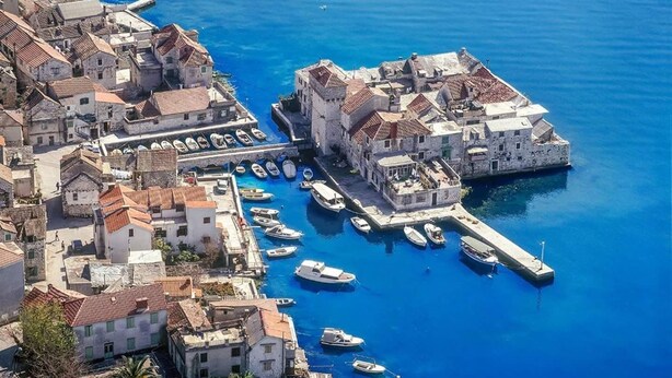 A coastal town with historic buildings, a marina with boats, and a clear blue sea. - Modern apartment near Split and Trogir (Kaštel Gomilica)