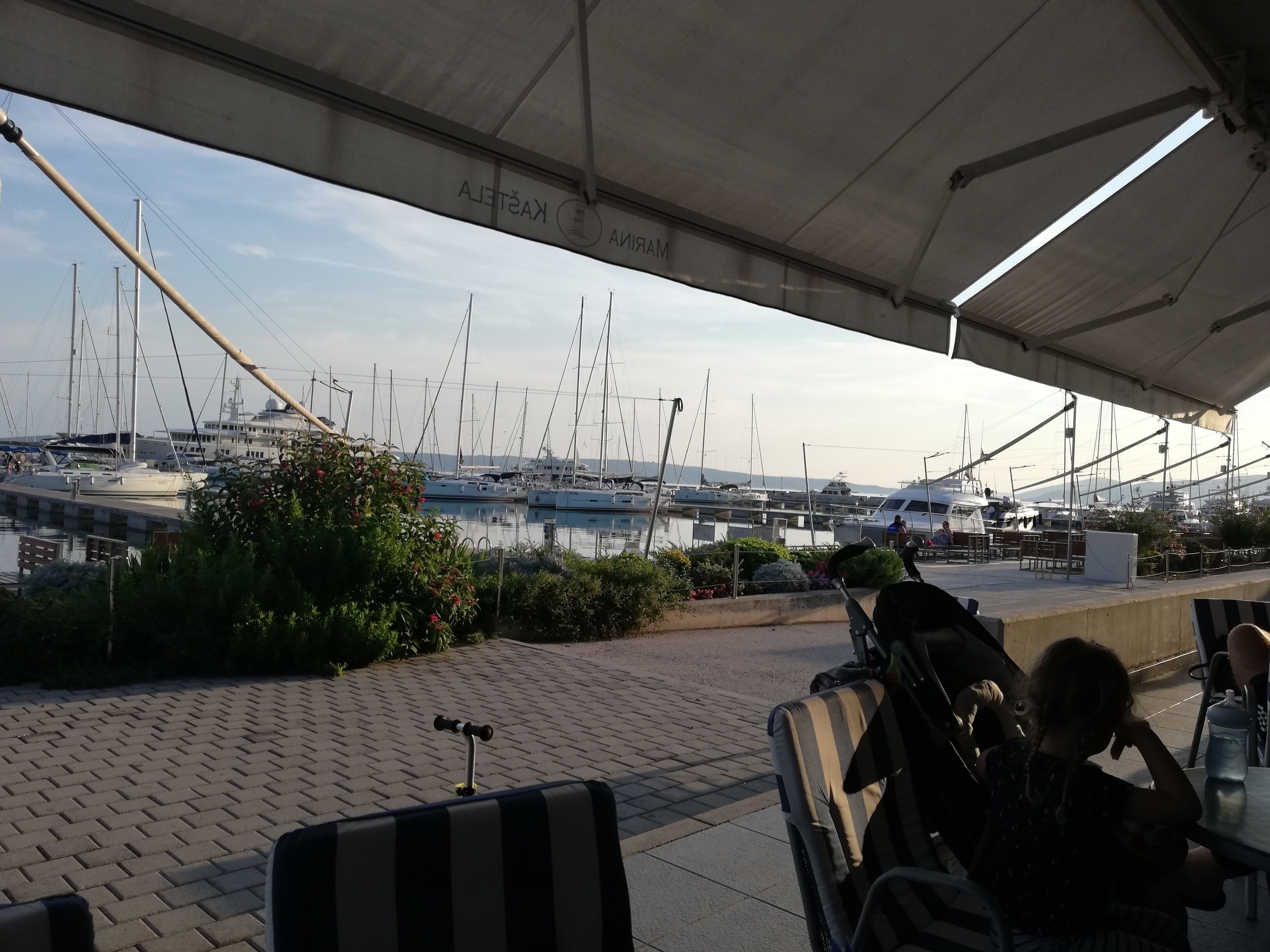 Un espacio de estar techado al aire libre con vistas a un puerto deportivo.