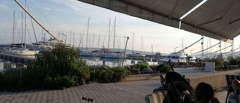 Un espacio de estar techado al aire libre con vistas a un puerto deportivo.