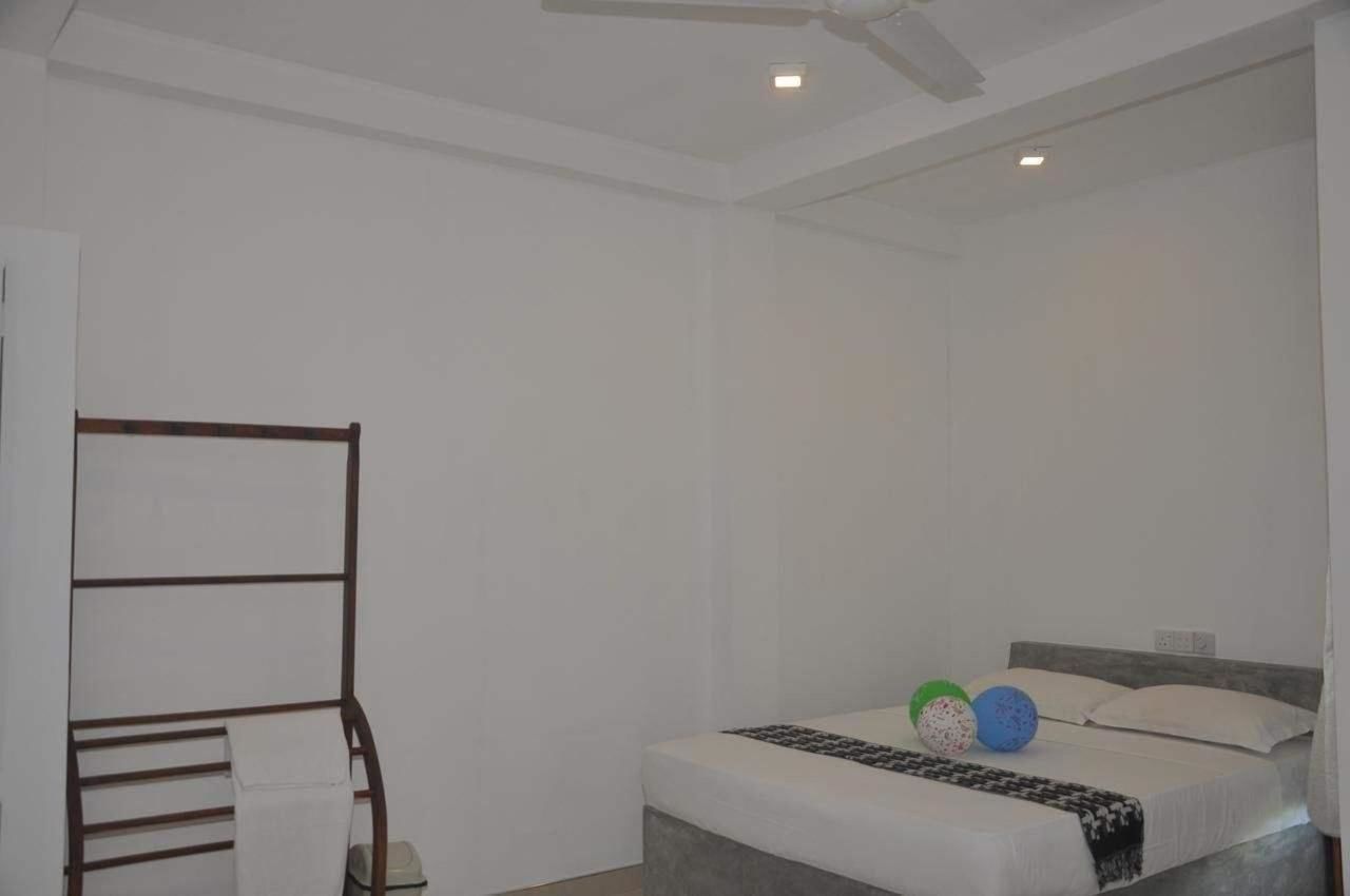 A bedroom with a bed, a wooden bench, and a ceiling fan.
