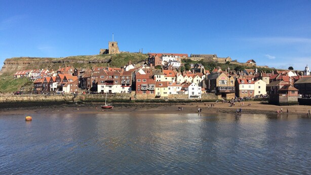 A coastal town with historic buildings, a prominent tower, and a castle on a hill. - The Cottage Gillamoor York, with wood burner, wifi and good local pub (Gillamoor)