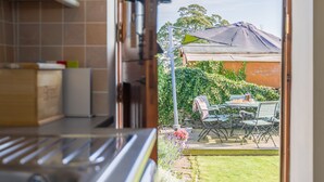 A kitchen with a view of an outdoor patio area. - The Cottage Gillamoor York, with wood burner, wifi and good local pub (Gillamoor)