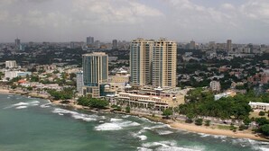 Paisagem costeira urbana com edifícios altos, uma praia e vista para o oceano.