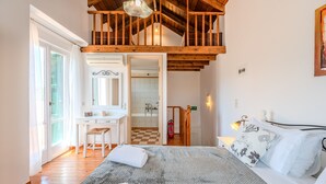 A bedroom with a bed, a desk, a bathroom, and a staircase. - Helianthos 1 ,Douliana, Near Vamos & Almirida (Chania)