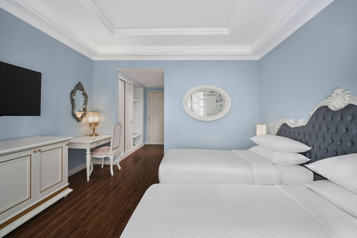 Une chambre d’hôtel avec un grand lit, un bureau et une chaise.