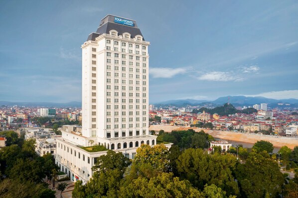 Un hotel blanco y alto con un cartel que dice "Four Points by Sheraton" en la parte superior.