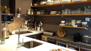 A modern kitchen with a stainless steel sink, a microwave, and a variety of kitchen utensils and appliances.