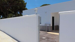 Un edificio blanco con una entrada pequeña y un portón de seguridad.