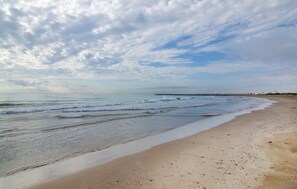 A beach with a wide sandy shore, gentle waves, and a distant pier. - Cozy apartment in La Pobla de Farnals (La Pobla de Farnals)
