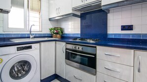 Una cocina moderna equipada con lavadora, horno y estufa a gas.