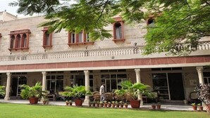 A building with a covered entrance, columns, and potted plants. - Hotel Arya Niwas, Jaipur (Jaipur)