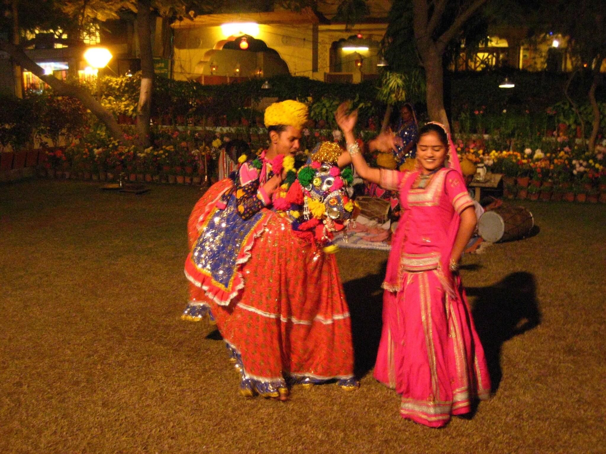 Deux personnes, vêtues de costumes traditionnels, exécutent une danse.
