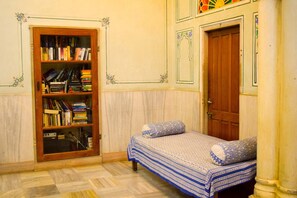 Une pièce avec un lit, une bibliothèque et une porte.