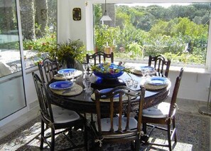 A dining table with blue plates and a central decorative bowl, surrounded by wooden chairs. - Paradise (customer´s evaluation) (Lagoa)