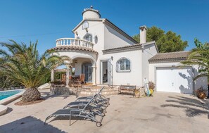 A two-story house with a balcony, a garage, and a pool.