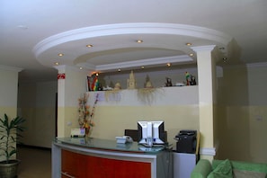 A reception desk with a glass top, a telephone, and a printer. - Natna Hotel (Addis Ababa)
